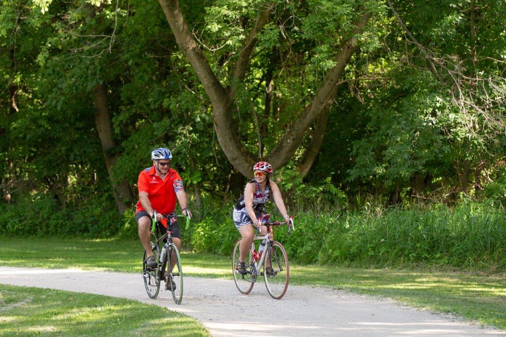 two people riding bike on trail