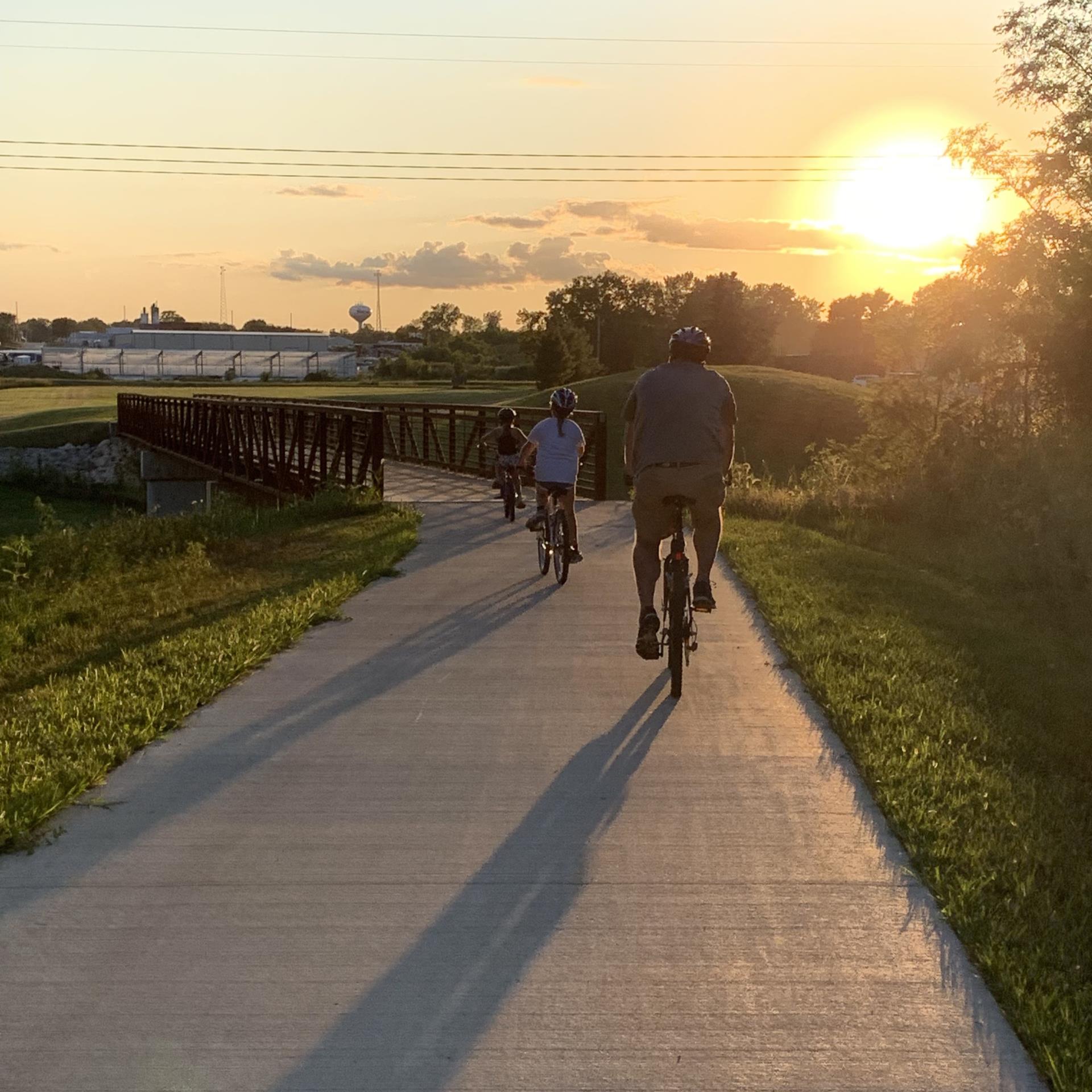 three people biking on a trail